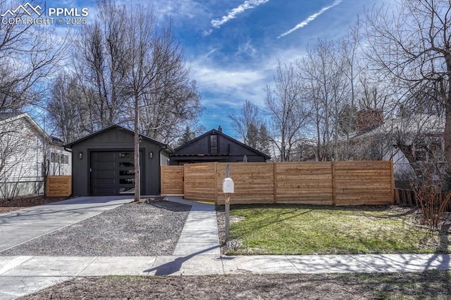 view of front facade featuring a fenced front yard and concrete driveway