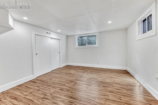 below grade area featuring recessed lighting, wood finished floors, visible vents, and baseboards