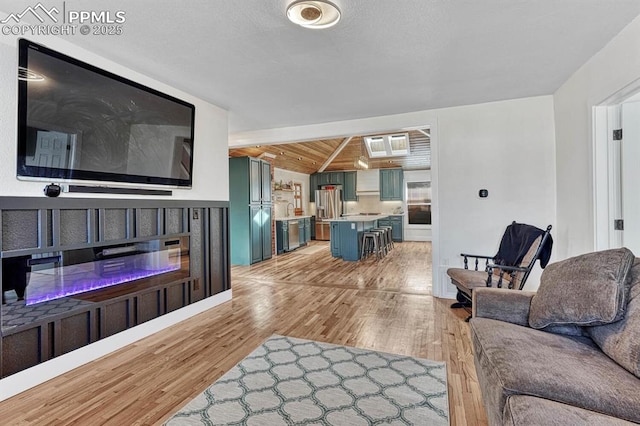 living room featuring wood ceiling, vaulted ceiling, and light wood-style flooring