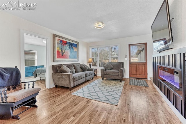 living room featuring light wood-style flooring and a textured ceiling