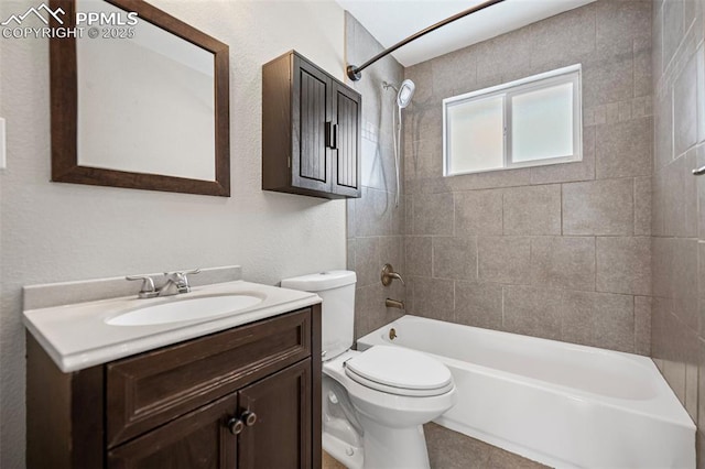 full bathroom featuring tiled shower / bath, vanity, and toilet