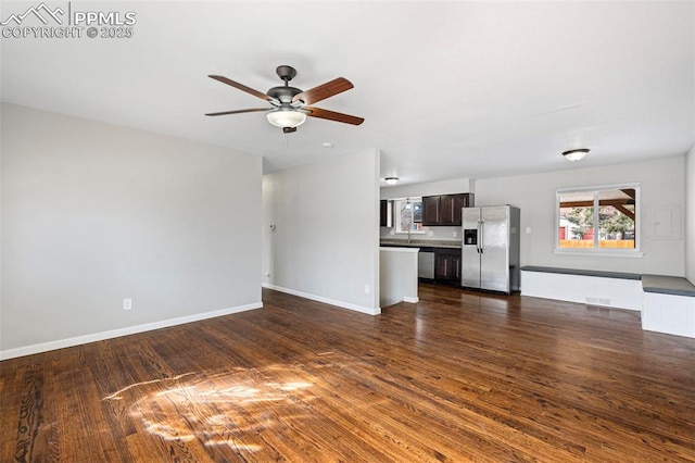 unfurnished living room with dark hardwood / wood-style flooring and ceiling fan