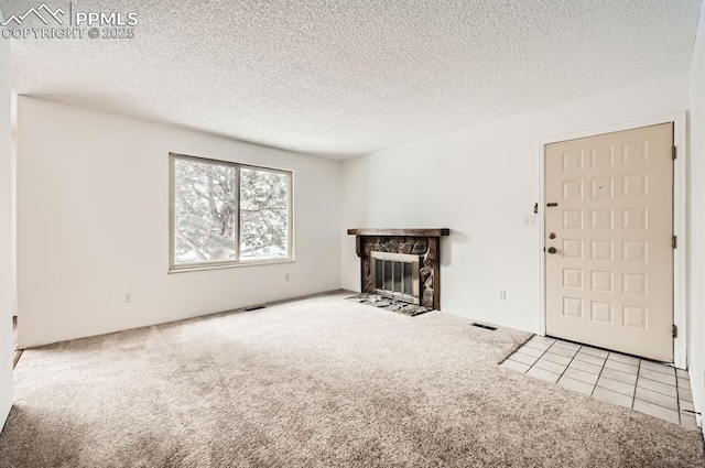 unfurnished living room featuring a fireplace, light carpet, and a textured ceiling