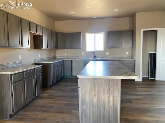 kitchen featuring a kitchen island, sink, and dark hardwood / wood-style flooring