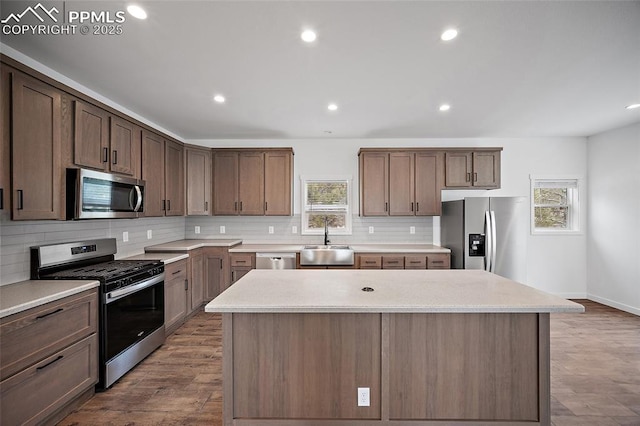 20 Apache Cir, Florissant, CO 80816 - kitchen featuring a wealth of natural light, a sink, tasteful backsplash, a kitchen island, and appliances with stainless steel finishes