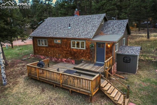 back of house featuring a wooden deck and a storage unit