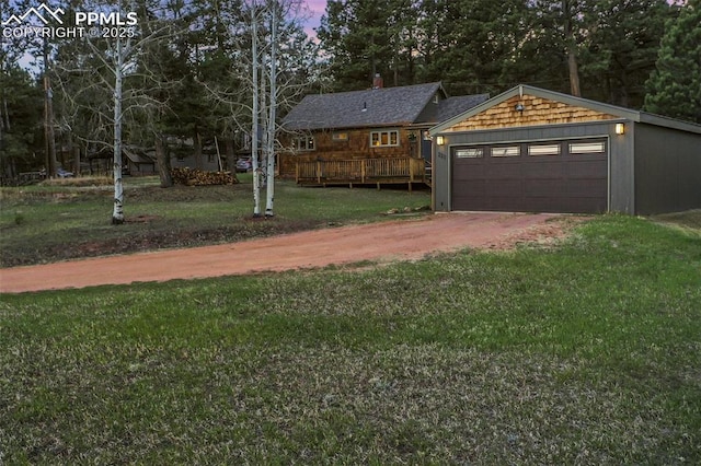 yard at dusk featuring a wooden deck and a garage