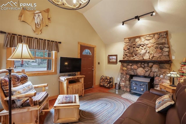 living room with hardwood / wood-style floors, track lighting, high vaulted ceiling, and a wood stove