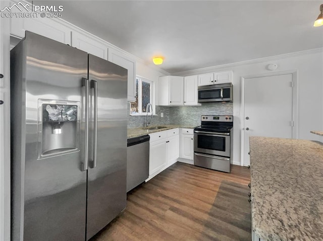 kitchen featuring appliances with stainless steel finishes, sink, white cabinetry, dark hardwood / wood-style floors, and tasteful backsplash