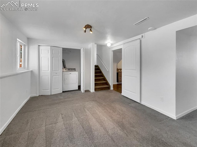 basement featuring washer / clothes dryer and dark colored carpet