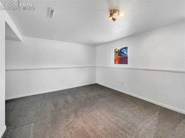 unfurnished room featuring dark carpet