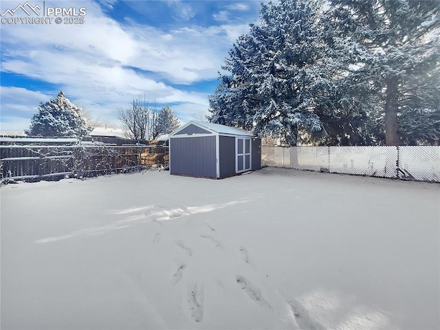 yard layered in snow with a storage unit