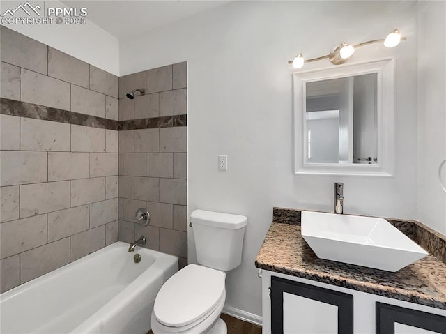 full bathroom featuring tiled shower / bath combo, vanity, and toilet