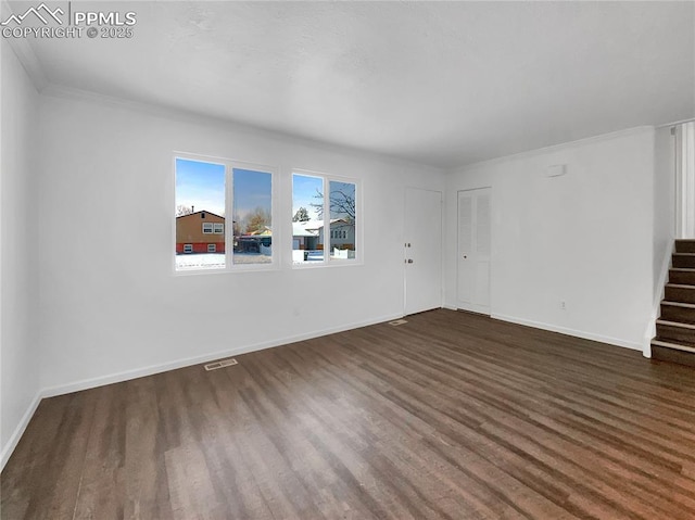 spare room with dark wood-type flooring and ornamental molding