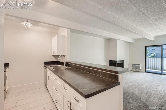 kitchen with white cabinetry, sink, beam ceiling, kitchen peninsula, and a textured ceiling