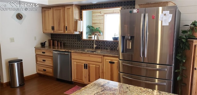 kitchen with tasteful backsplash, stone countertops, dark wood-type flooring, stainless steel appliances, and a sink