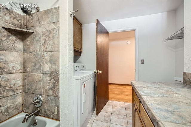 clothes washing area featuring washer / dryer and light tile patterned floors