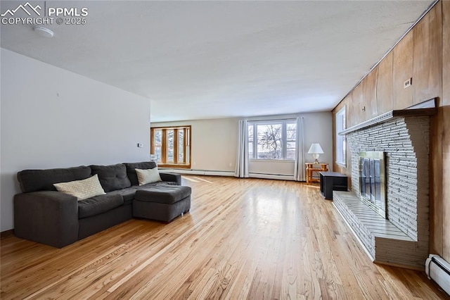 living room with a baseboard heating unit and light wood-type flooring