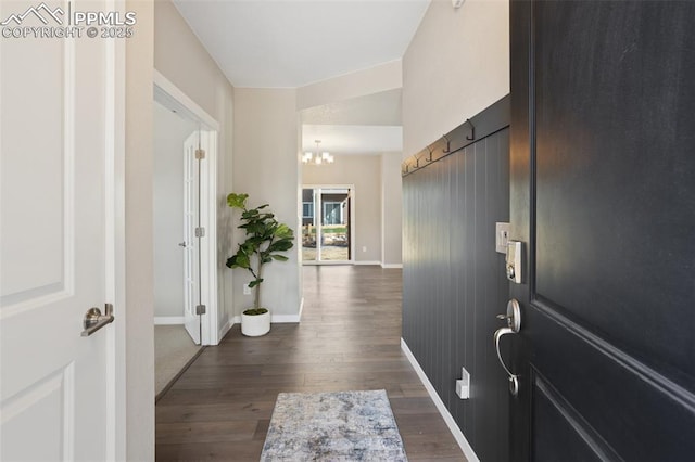 foyer with dark hardwood / wood-style floors and a chandelier