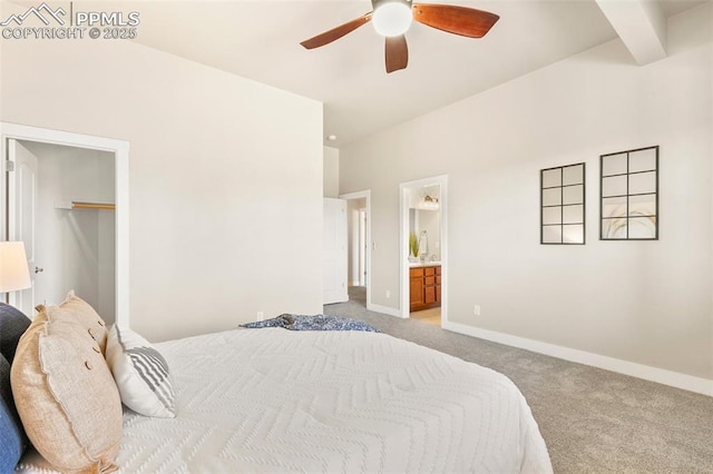 carpeted bedroom with ensuite bathroom, beamed ceiling, and ceiling fan