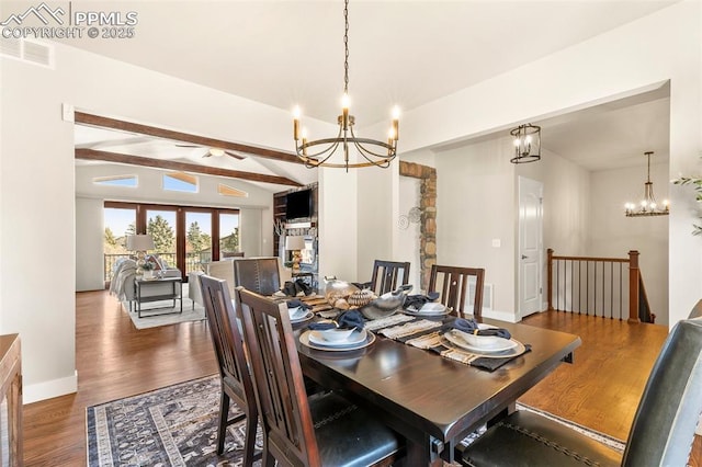 dining area featuring a fireplace, vaulted ceiling with beams, an inviting chandelier, and dark hardwood / wood-style floors