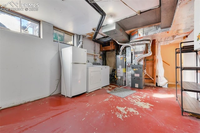 basement with white refrigerator, gas water heater, heating unit, and washer and clothes dryer