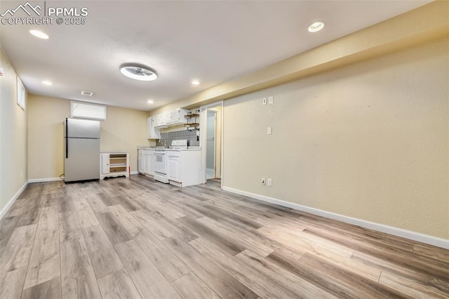 interior space with light wood-type flooring, beverage cooler, and stainless steel refrigerator