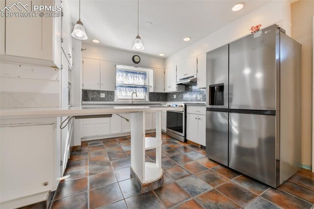 kitchen with appliances with stainless steel finishes, pendant lighting, white cabinetry, sink, and backsplash