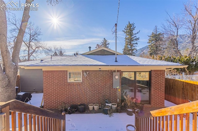 snow covered house featuring a deck with mountain view