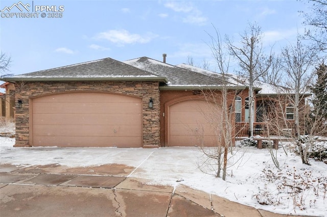 view of front of house featuring an attached garage, stone siding, driveway, and a shingled roof