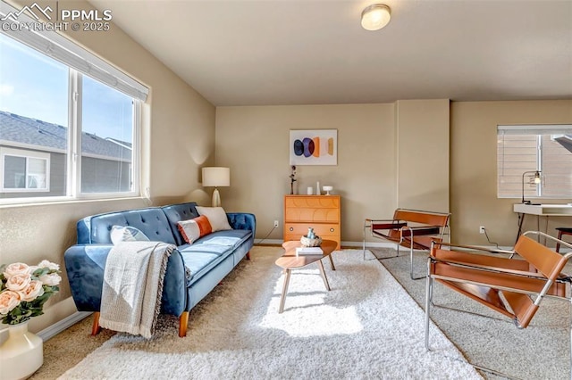 carpeted living area featuring baseboards