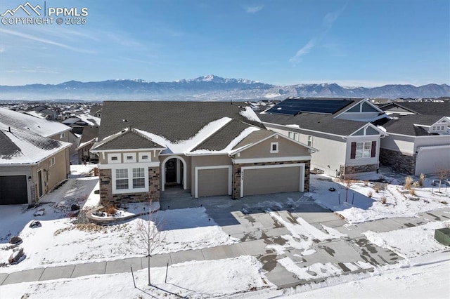 ranch-style house with a garage and a mountain view