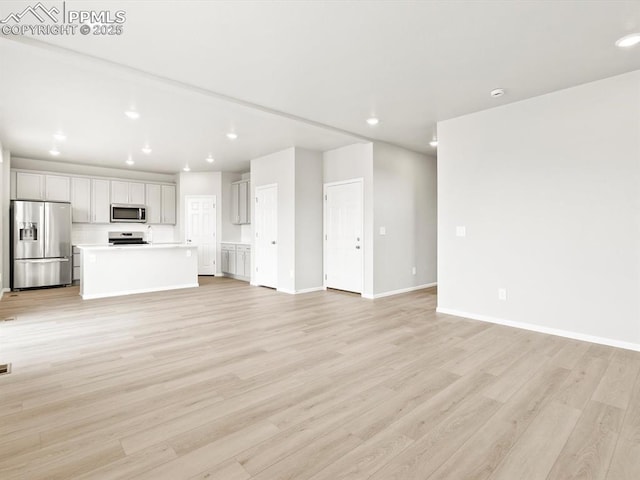 unfurnished living room featuring light wood-style flooring, recessed lighting, and baseboards