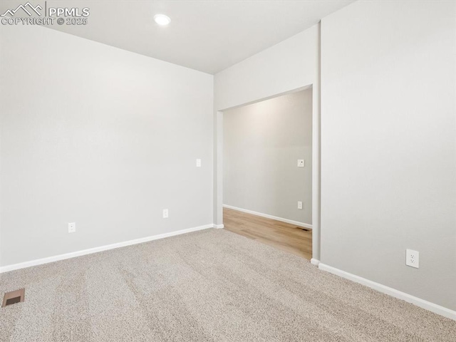carpeted empty room featuring recessed lighting, visible vents, and baseboards