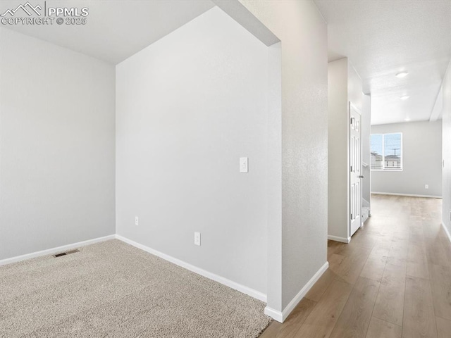 interior space with visible vents, baseboards, and wood finished floors
