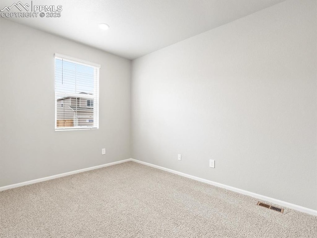 empty room featuring visible vents, baseboards, and carpet flooring