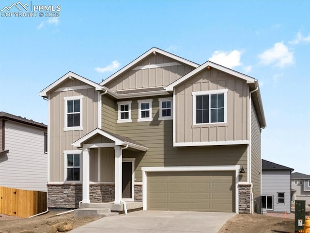 craftsman-style home featuring board and batten siding, fence, concrete driveway, stone siding, and an attached garage