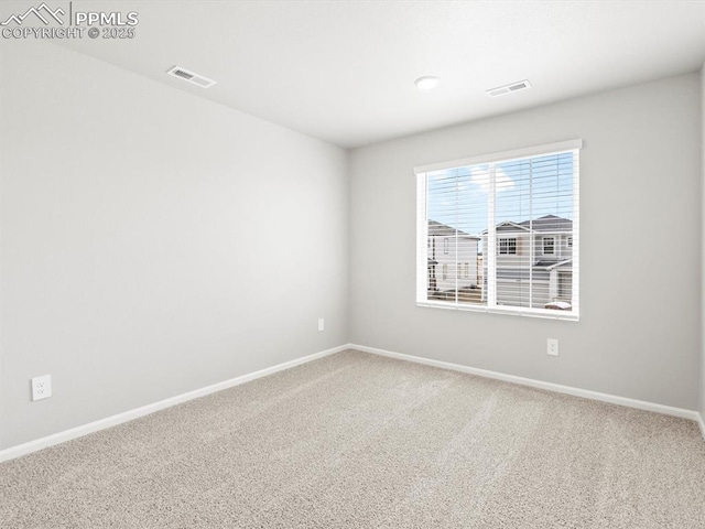 empty room featuring baseboards, visible vents, and carpet floors