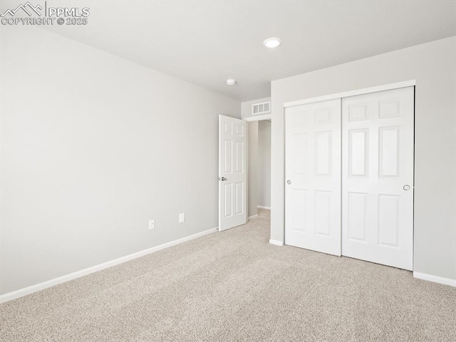unfurnished bedroom featuring visible vents, baseboards, a closet, and carpet flooring
