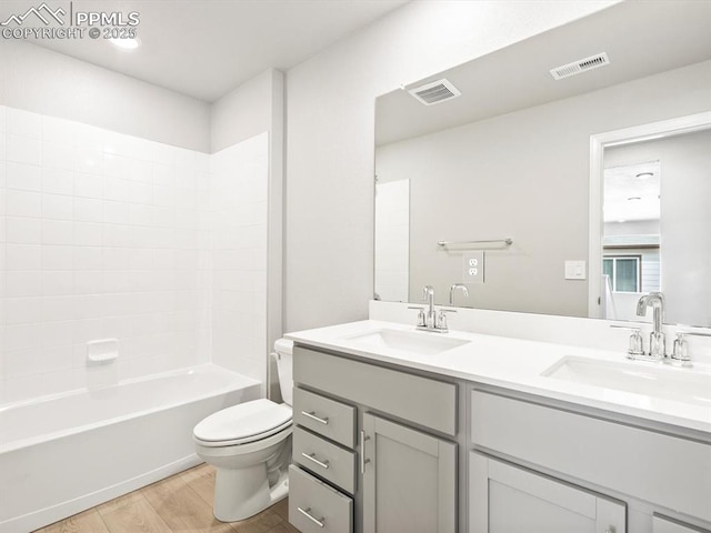 full bathroom with toilet, visible vents, and a sink
