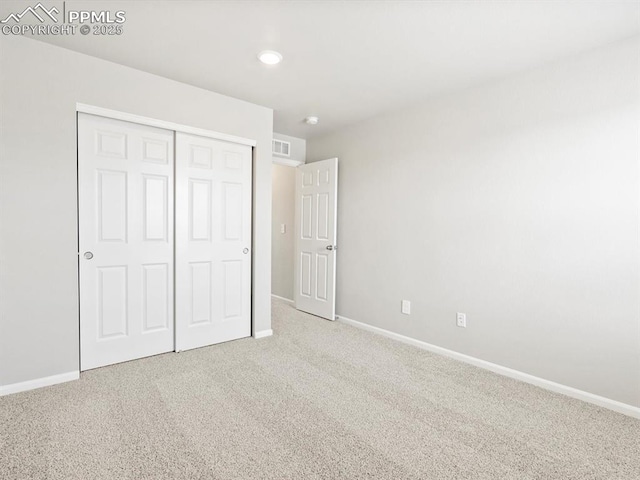 unfurnished bedroom featuring a closet, visible vents, baseboards, and carpet floors