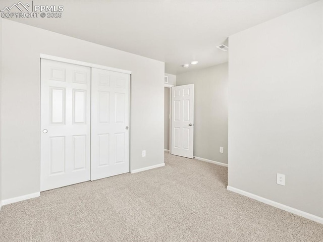unfurnished bedroom featuring carpet flooring, visible vents, baseboards, and a closet