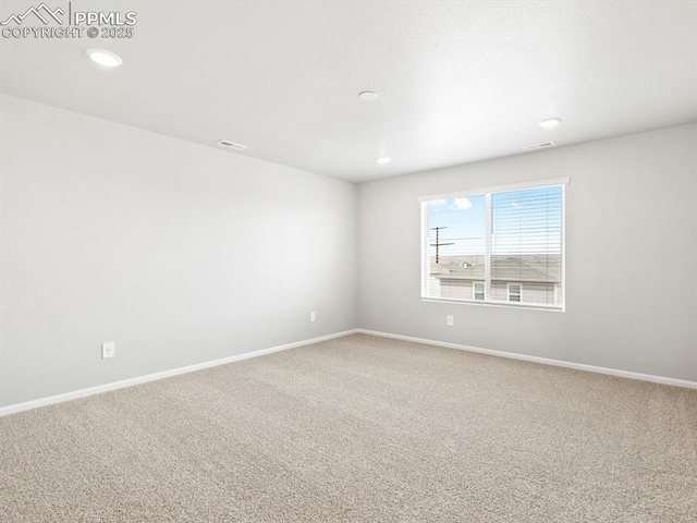 empty room with visible vents, carpet, and baseboards