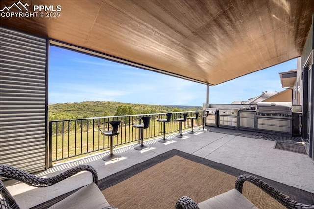 view of patio with a balcony, exterior kitchen, and area for grilling