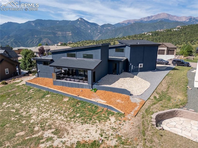 view of front of home with a garage and a mountain view