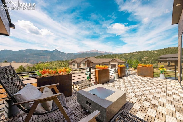 view of patio / terrace with a mountain view and a fire pit