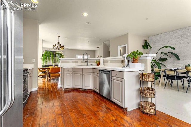 kitchen featuring appliances with stainless steel finishes, sink, a kitchen island with sink, and dark hardwood / wood-style flooring