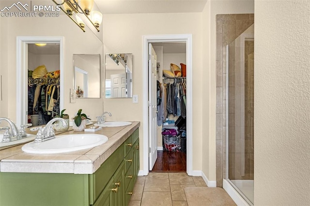 bathroom with an enclosed shower, vanity, and tile patterned flooring