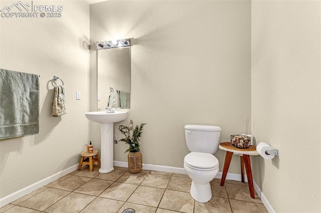 bathroom with tile patterned flooring, sink, and toilet