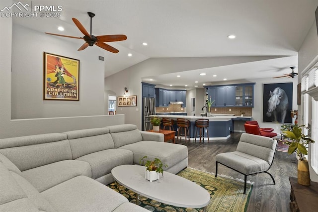 living room featuring a ceiling fan, dark wood finished floors, vaulted ceiling, and recessed lighting